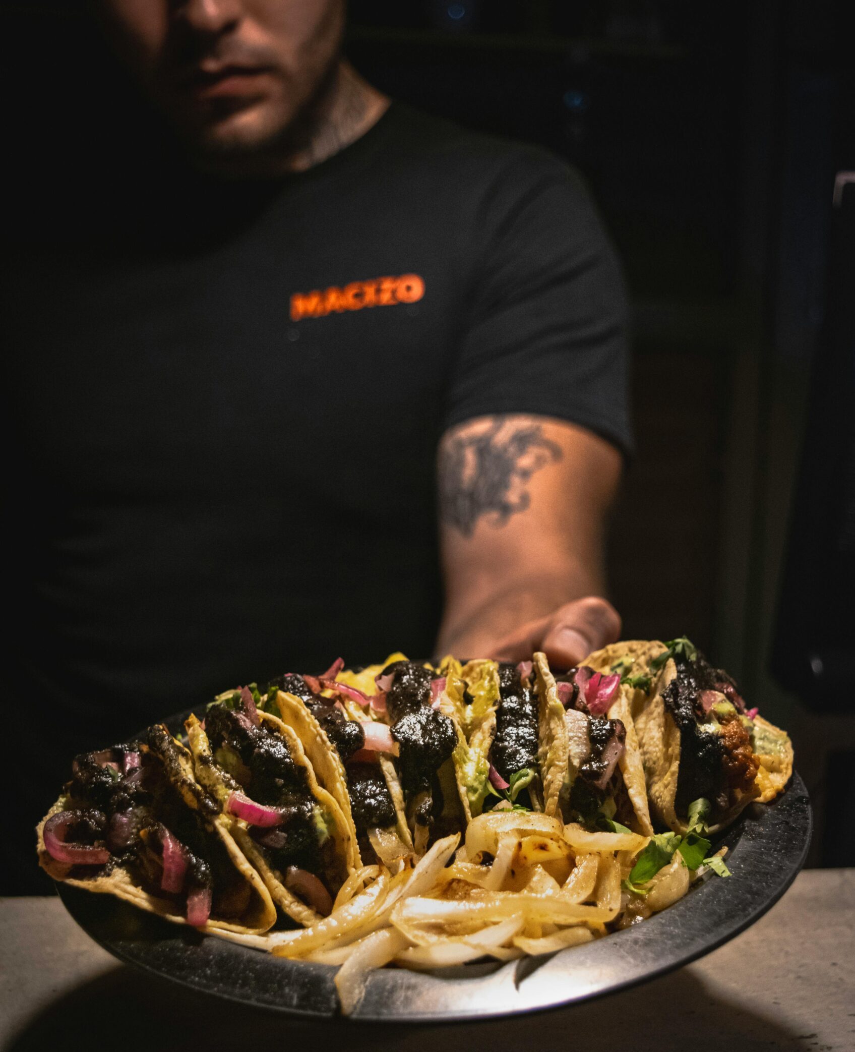 Gourmet beef tacos served with toppings on a plate in a Mexican restaurant.